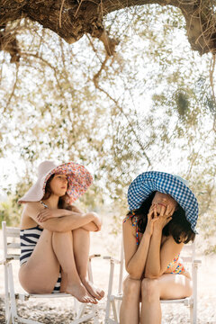 Women seated under olive tree