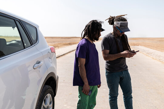 Travelling friends checking GPS navigation system on smartphone