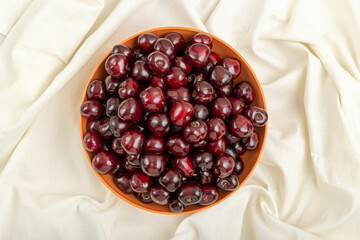 Ripe cherries in a bowl on a white tablecloth