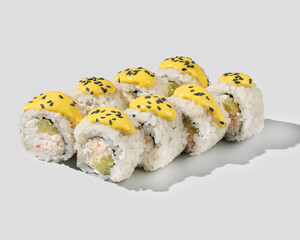A delicious arrangement of sushi rolls topped with vibrant yellow sauce and sesame seeds, perfect for Japanese cuisine enthusiasts