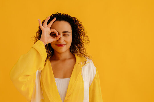 Charming woman with ok gesture on eye