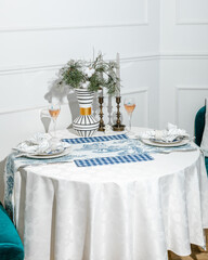 Elegant table setting with white tablecloth and festive decorations, perfect for Christmas dinner or holiday celebrations