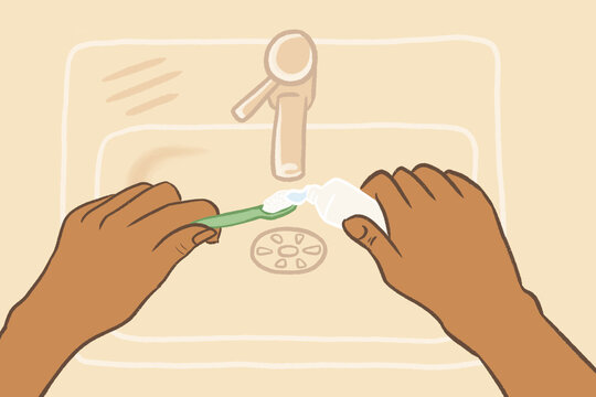 Hands squeezing toothpaste onto a toothbrush