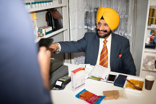 Indian Business Owner Selling Goods At His Shop
