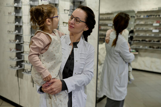 female optician with a little girl in an optical storer 