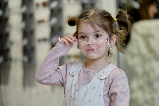 little girl trying on glasses