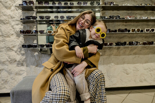 Mom and her little daughter choose glasses