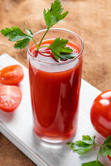 Dietary tomato juice on a linen background. Healthy drink made from farm vegetables.