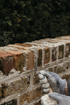 Artisan using tool on brick wall