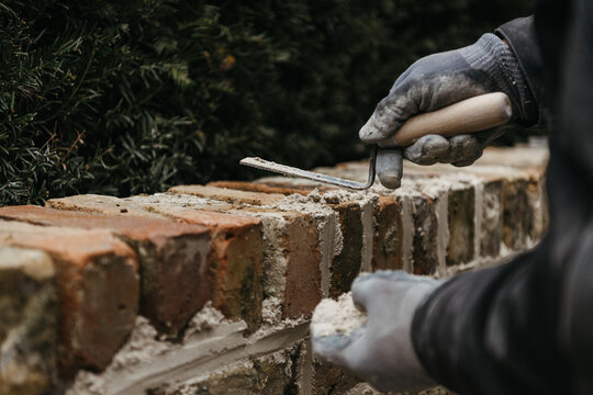 Mason perfecting brick wall alignment