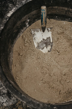 Cement in bucket with mason's trowel