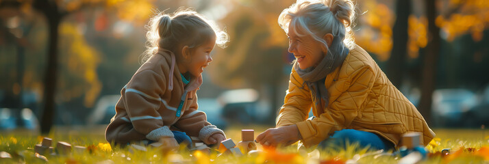 Caucasian grandmother and granddaughter playing with wooden toys on the grass in the park.