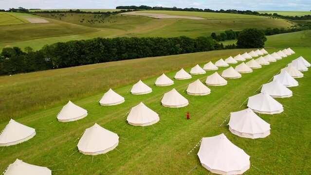 Aerial shot of Rows of Glamping tents overlooking the Chalke History Festival taking place in the Chalke Valley on a summers day in UK
