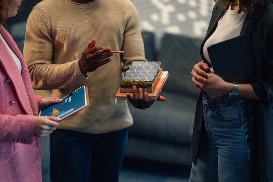 Close up of diverse environmentalists with solar panel model at office