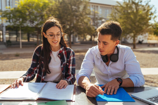 Studious college classmates with books reading for exams