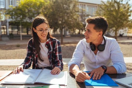 Cheerful students with books and file during studies
