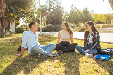 Friends sitting on campus grass