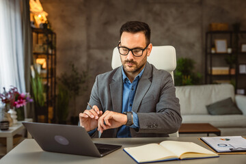 Adult man with beard work from home and look at the clock