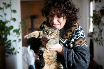 Woman Holding Cat in Cozy Home Environment