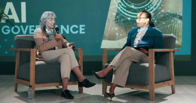 Conference, business women and speaker at stage with host for question, talking or speech at startup. Guest, technology and event at seminar for presentation on ai governance, training and coaching