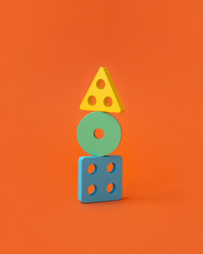 Colorful constructor toy blocks stacked on orange background. 
