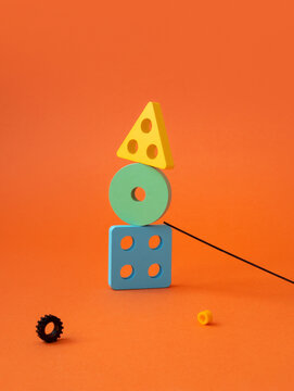 Colorful constructor toy blocks stacked on orange background. 