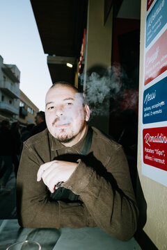 Man Vaping Outdoors at a Cafe