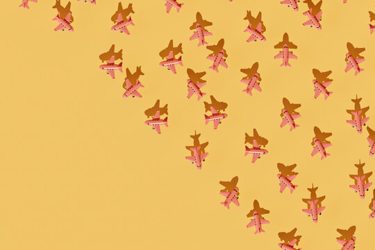 Repetitive Pattern of Pink Paper Airplanes on Yellow Background