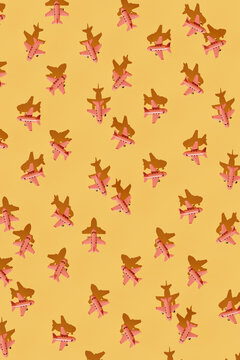 Pattern of Pink Paper Airplanes on Yellow Background