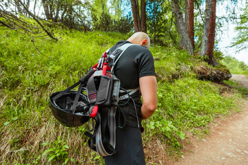 Climber with Climbing Equipment Hiking up the Mountain Trail