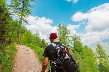 Climber with Red Cap Climbing Equipment Hiking up the Mountain Trail