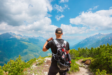 Hiker in Hero Pose Looking Into the Distant Mountain Landscape