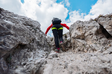 Hiker Hiking up a Narrow Rocky Mountain Trail