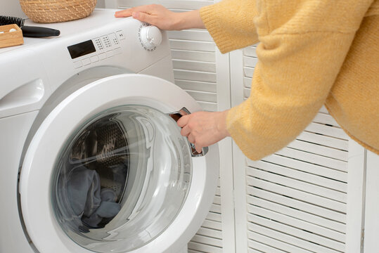 Woman opening washing machine