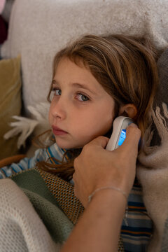 A sick child getting her fever checked