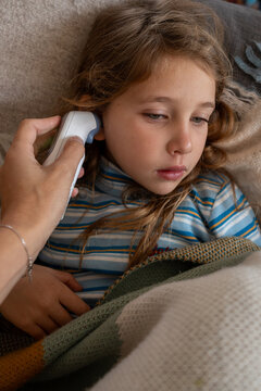 A sick child getting her fever checked