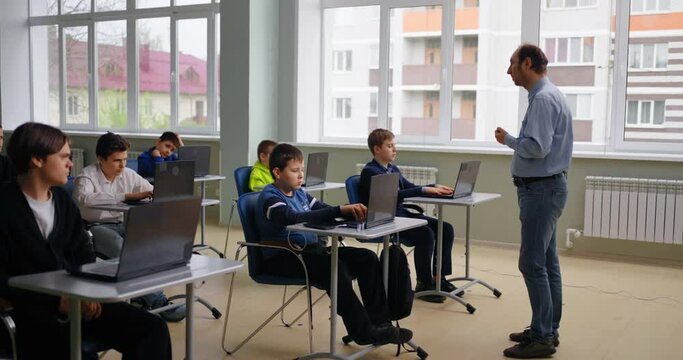 Teacher Speaking In Computer-Based Class, Diverse School Boys Learning In Coding Class, Smart Kids