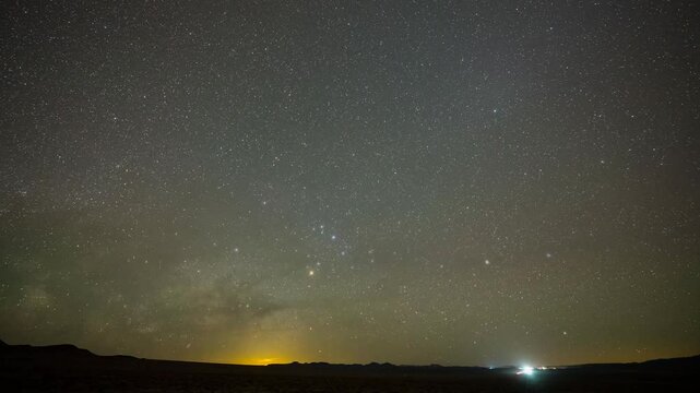 Milky Way time lapse along a highway with passing cars in Nevada 