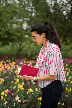 Non-binary person writing on notebook 