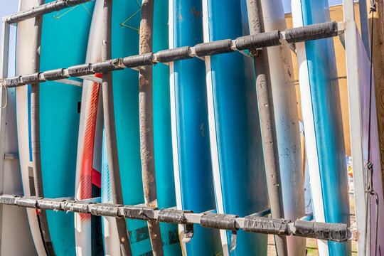 Colorful Surfboards Lined Up On A Sunny Beach.