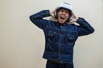 A Southeast Asian man wearing helmt and scream isolated over cream background, driver taxi online. stock photo.