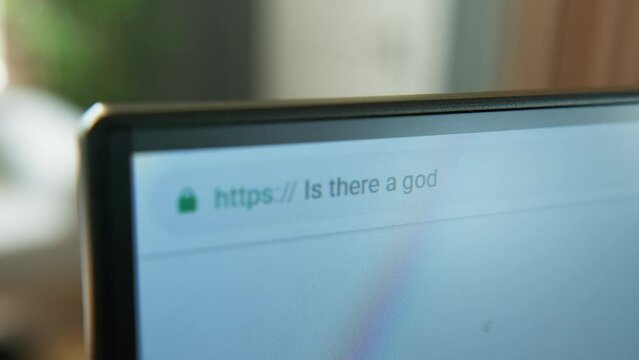 A close-up shot of a computer monitor displaying a web browser, focusing on the address bar and URL. Searching in browser ''is there a god?''
