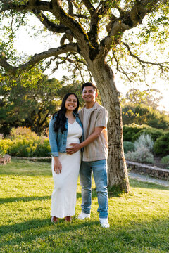 Portrait of happy pregnant couple outside 