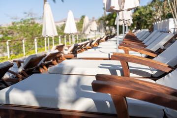Line Of Wooden Lounge Chairs By The Pool