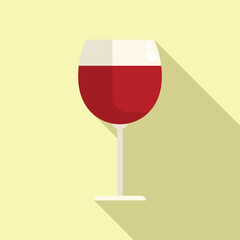 Classic wine glass is standing filled with red wine and casting a long shadow