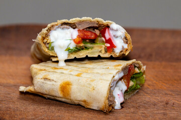 Traditional Shawarma sandwich fresh roll of, Grilled Meat and salad tortilla wrap with white sauce isolated on white background. Details