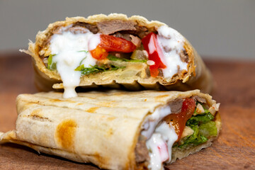 Traditional Shawarma sandwich fresh roll of, Grilled Meat and salad tortilla wrap with white sauce isolated on white background. Details