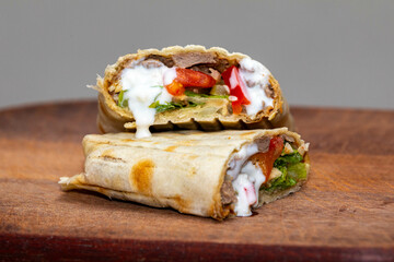 Traditional Shawarma sandwich fresh roll of, Grilled Meat and salad tortilla wrap with white sauce isolated on white background. Details