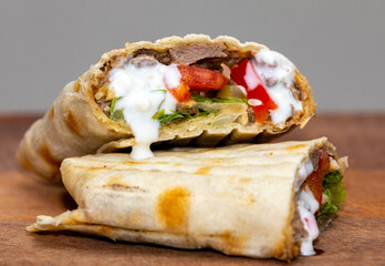 Traditional Shawarma sandwich fresh roll of, Grilled Meat and salad tortilla wrap with white sauce isolated on white background. Details