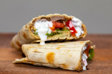 Traditional Shawarma sandwich fresh roll of, Grilled Meat and salad tortilla wrap with white sauce isolated on white background. Details